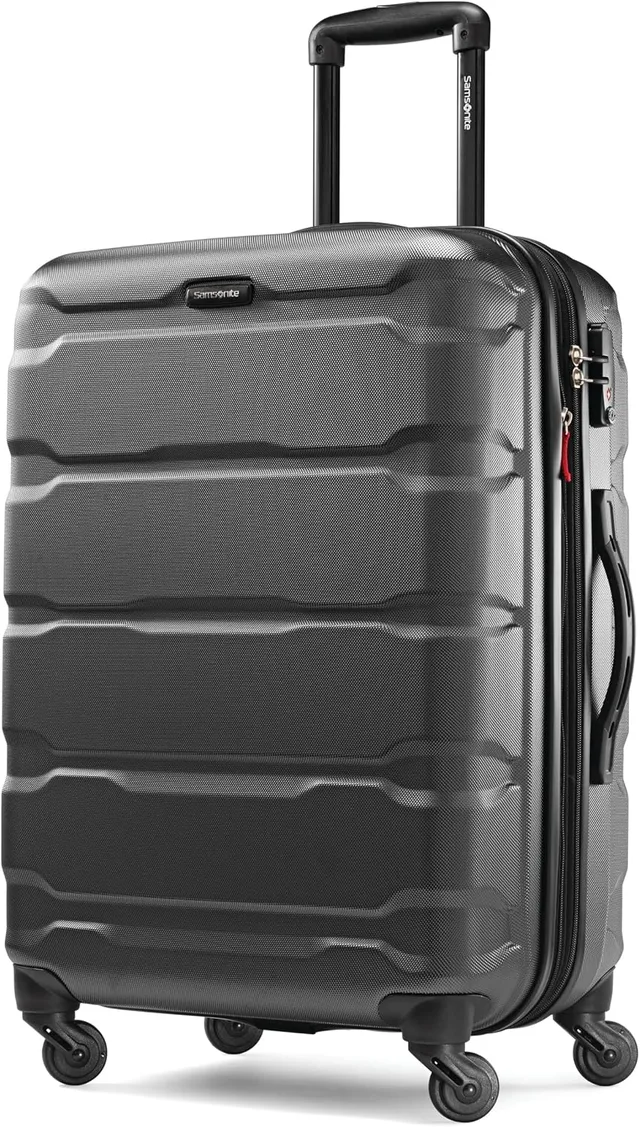 A matching three-piece Samsonite Omni PC hardside spinner set in black, with the carry-on, medium, and large checked bags standing in a row